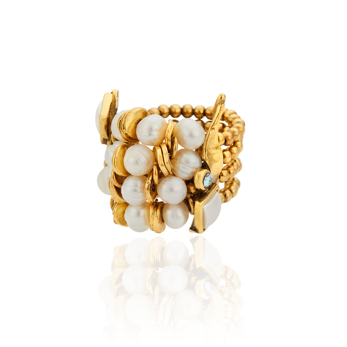 Bracelete da Coleção Ofertar, com design sofisticado e textura marcante. A peça combina acabamento dourado, pérolas naturais de diferentes formatos e tamanhos, cristais e elementos metálicos, criando uma composição rica em brilho, volumes e contrastes. Detalhe quadrado em tom claro complementa a joia, que traduz a proposta da coleção de celebrar generosidade, afeto, presença e o gesto de oferecer.