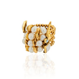 Bracelete da Coleção Ofertar, com design sofisticado e textura marcante. A peça combina acabamento dourado, pérolas naturais de diferentes formatos e tamanhos, cristais e elementos metálicos, criando uma composição rica em brilho, volumes e contrastes. Detalhe quadrado em tom claro complementa a joia, que traduz a proposta da coleção de celebrar generosidade, afeto, presença e o gesto de oferecer.