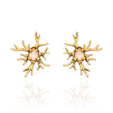 Brinco Galhos Ouro Peregrinar Camila Klein, com design inspirado em galhos e formas orgânicas, destaque para o cristal central em tom champagne e estrutura com acabamento dourado. Confeccionado em cristais e metais com banho em ouro velho, possui visual marcante e sofisticado, ideal para adicionar personalidade e elegância às produções.