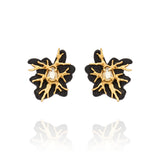 Brinco pequeno Preto Ouro Peregrinar Camila Klein, com design orgânico inspirado em galhos, resina preta e cristal central em tom champagne. Confeccionado em cristais, resina preta e metais com banho em ouro velho, combina contraste, sofisticação e personalidade em uma peça marcante e elegante.