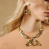 Colar Camila Klein Verão em Cores, com acabamento dourado e composição sofisticada de pedras em tons verdes, azuis e terrosos. O design autoral combina elementos orgânicos e detalhes esféricos, criando uma joia marcante, leve e vibrante. Peça inspirada na natureza, perfeita para produções de verão e looks cheios de personalidade.