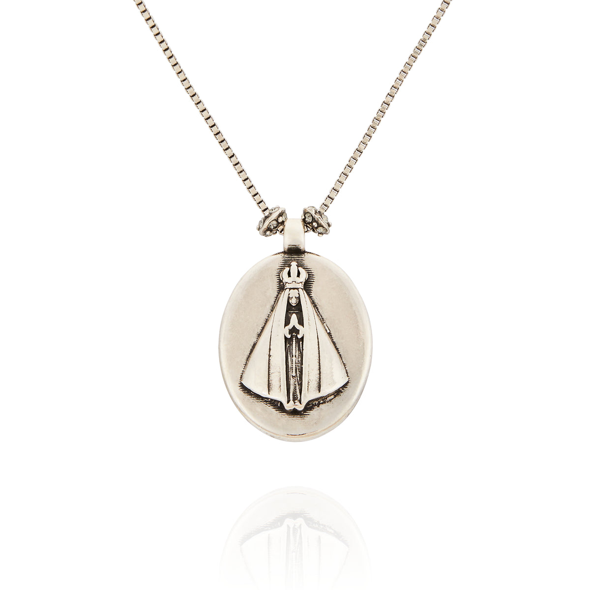 Colar Religare Camila Klein com medalha oval prateada em metal, detalhe religioso em relevo e corrente delicada. Joia de design autoral inspirada na espiritualidade, fé e proteção, com acabamento sofisticado que combina simbolismo e elegância. Acessório exclusivo da linha Religare, marca de joias e semijoias de luxo Camila Klein.