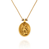 Colar Religare Camila Klein com medalha oval dourada em metal, apresentando imagem religiosa em relevo com detalhes ornamentais e corrente delicada. Joia de design autoral inspirada na espiritualidade, fé e proteção, que une simbolismo e sofisticação. Acessório exclusivo da linha Religare, marca de joias e semijoias de luxo Camila Klein.
