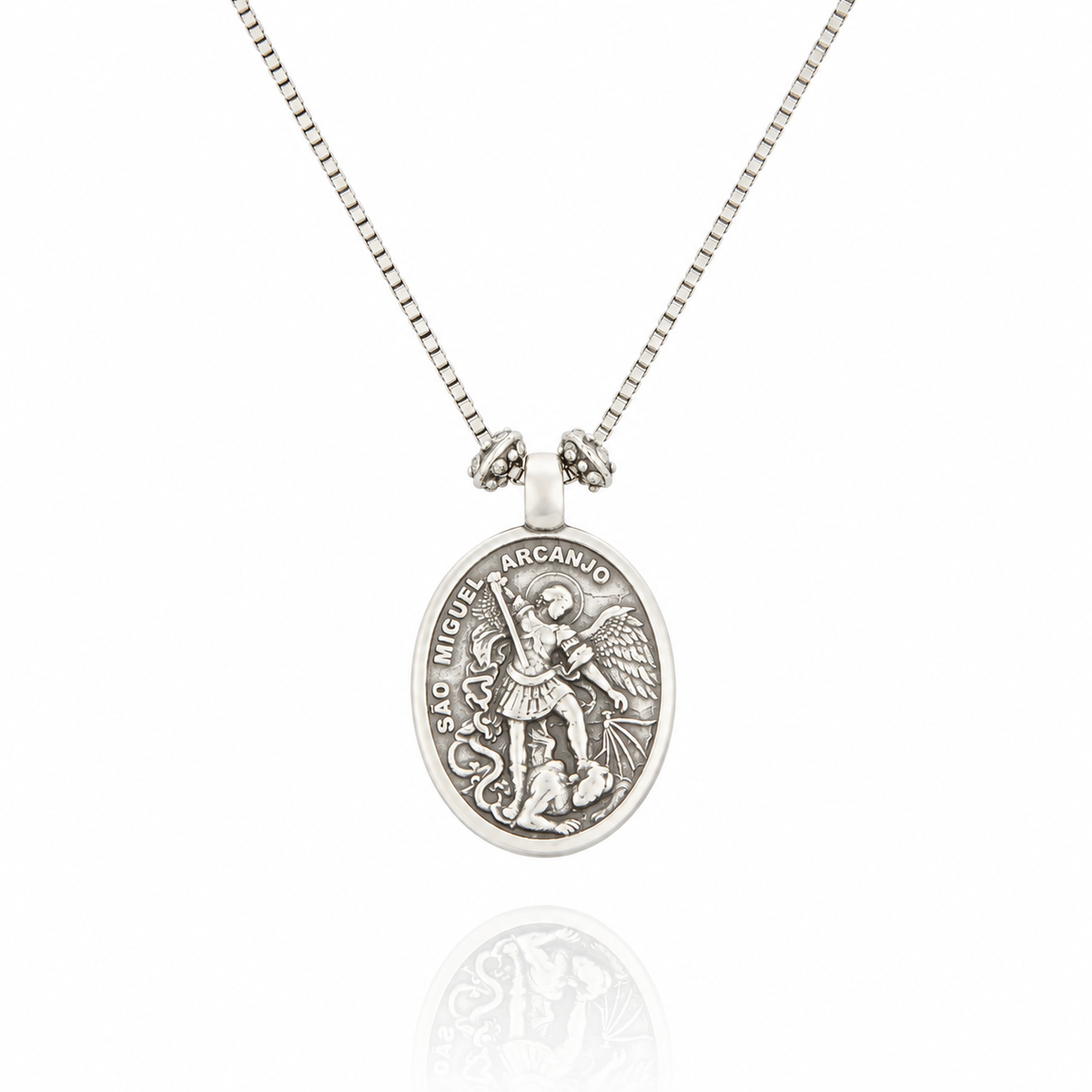Colar Religare Camila Klein com medalha oval prateada em metal, apresentando imagem religiosa em relevo com detalhes ornamentais e corrente delicada. Joia de design autoral inspirada na espiritualidade, fé e proteção, que une simbolismo e sofisticação. Acessório exclusivo da linha Religare, marca de joias e semijoias de luxo Camila Klein.