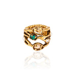 Meio Anel Cristais Ouro Peregrinar da Camila Klein, em metal com banho de ouro velho, com design orgânico e vazado formado por linhas irregulares. O anel apresenta cristais em diferentes tonalidades, incluindo cristal transparente, verde-azulado e rosado, aplicados em diferentes pontos da peça. O aro possui acabamento texturizado e detalhes que remetem a formas naturais, com uma composição sofisticada e artesanal. Fotografia do anel sobre fundo branco, com reflexo da peça na superfície.